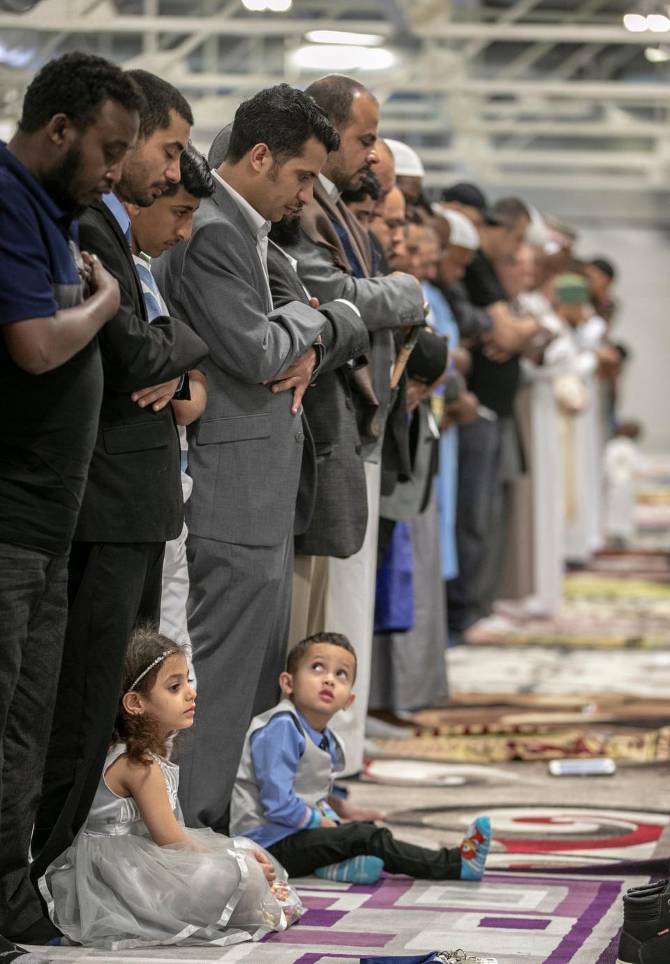 Children watch their fathers pray during an event called Eid al-Fitr, which helps mark the end of Ramadan, a fast for Muslims during daylight hours, and lasting one lunar cycle, at the Indiana State Fairgrounds, Indianapolis, Tuesday, June 4, 2019. The event, drawing a few thousand Muslims, is one of several community ones in the area designed to bring various Islamic communities together. 