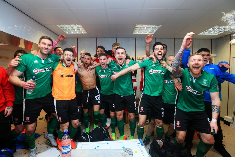 Lincoln City team celebrate their win in the changing room after The Emirates FA Cup Fifth Round match between Burnley and Lincoln City at Turf Moor