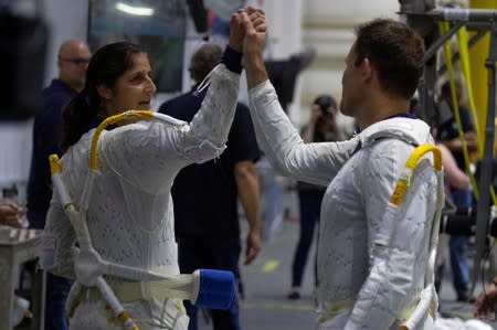 NASA Commercial Crew astronaut Sunita Williams high-fives fellow astronaut Josh Cassada before being fitted into the space suits at the start of training at NASA's Neutral Buoyancy Laboratory (NBL) facility near the Johnson Space Center in Houston