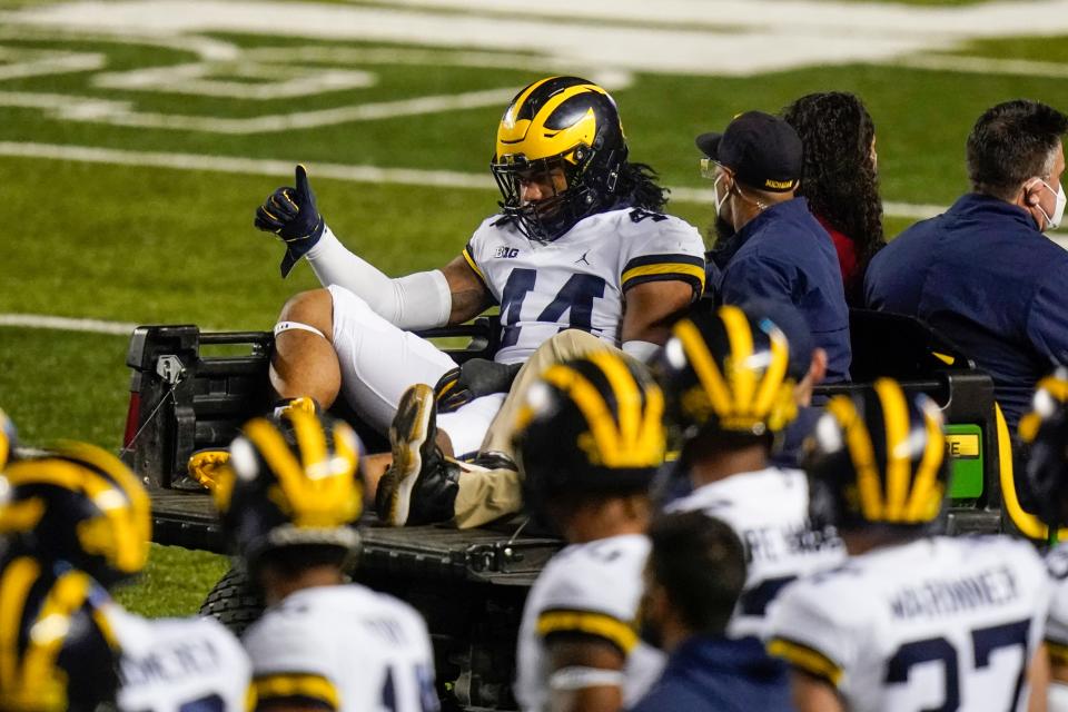 Michigan's Cameron McGrone gives a thumbs-up to teammates as he is carted off the field after being injured during the game against Rutgers on Nov. 21, 2020, in Piscataway, N.J.