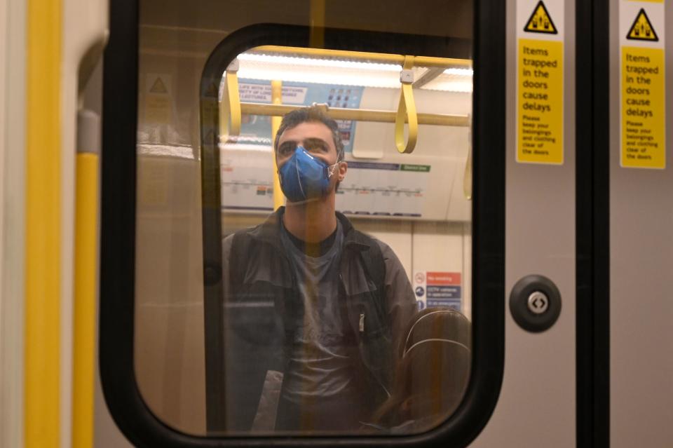 A man wearing a mask stands in an underground train in London on March 14, 2020. - British Prime Minister Boris Johnson, who has faced criticism for his country's light touch approach to tackling the coronavirus outbreak, is preparing to review its approach and ban mass gatherings, according to government sources Saturday. (Photo by Glyn KIRK / AFP) (Photo by GLYN KIRK/AFP via Getty Images)