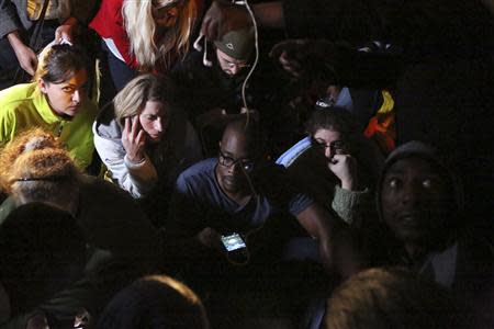People listen to a radio as South African President Jacob Zuma announces the death of former South African President Nelson Mandela in Houghton, December 5, 2013. REUTERS/Siphiwe Sibeko