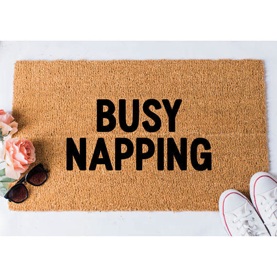 <a href="https://www.etsy.com/listing/281427940/busy-napping-doormat-funny-mat-welcome?gpla=1&amp;gao=0&amp;utm_campaign=shopping_us_foxandcloverboutique_sfc_osa&amp;utm_medium=cpc&amp;utm_source=google&amp;utm_custom1=0&amp;utm_content=8899028&amp;gclid=Cj0KCQjwoZTNBRCWARIsAOMZHmFgYA_0SEE4V7RoEawV1Gm2A2y62HK3zuzMdXk6RHYUMA57TLkAdyEaAr1BEALw_wcB" target="_blank">Shop it here</a>.&nbsp;