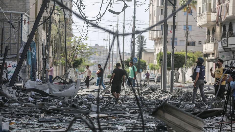 Palästinenser inspizieren das Umfeld des schwer beschädigten Al-Jawhara-Turm, nachdem der Turm von israelischen Luftangriffen getroffen worden war.