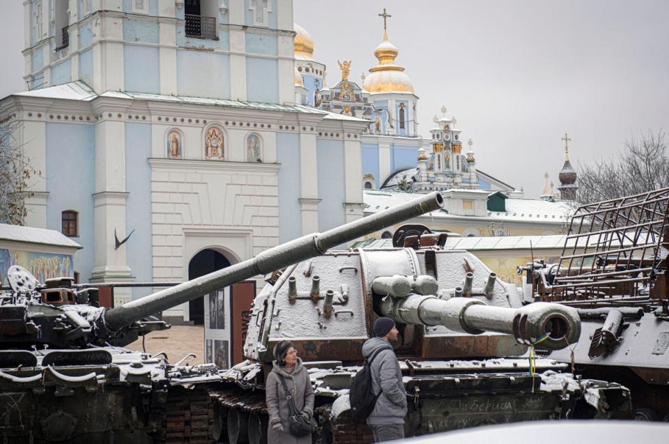 Des habitants marchent entre des chars russes capturés et des véhicules blindés à Kyiv jeudi (AP)