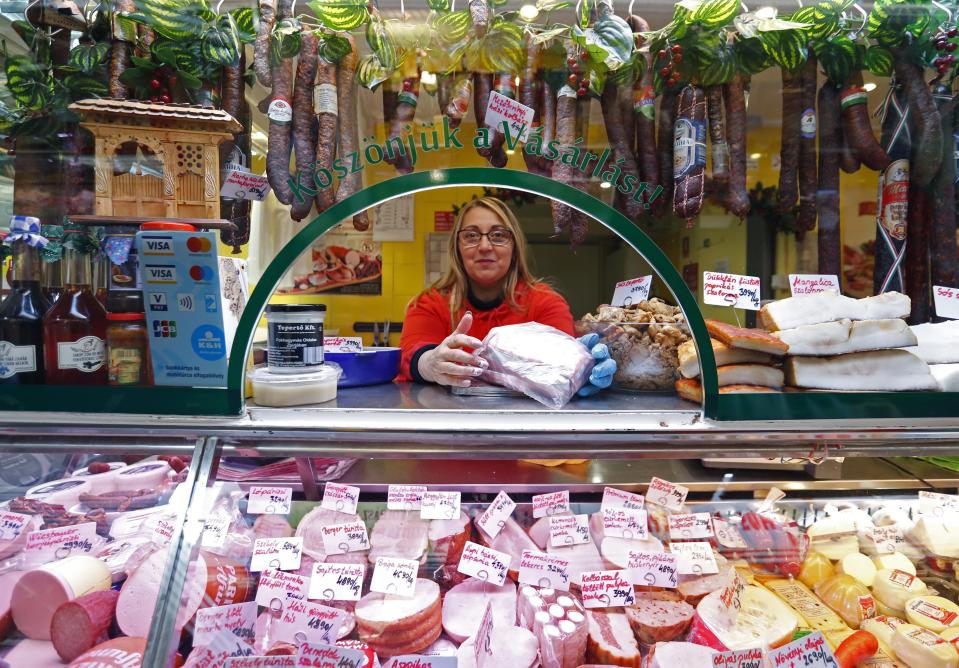 A vendor sells food items, at a food market in Budapest, Hungary, Nov. 20, 2021. From appliance stores in the United States to food markets in Hungary and gas stations in Poland, rising consumer prices fueled by high energy costs and supply chain disruptions are putting a pinch on households and businesses worldwide. As economies recover from lockdowns caused by the COVID-19 pandemic, increased consumer demand has helped lead to rising inflation. (AP Photo/Laszlo Balogh)