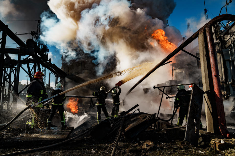 Firefighters shoot water at a fire at a power station.