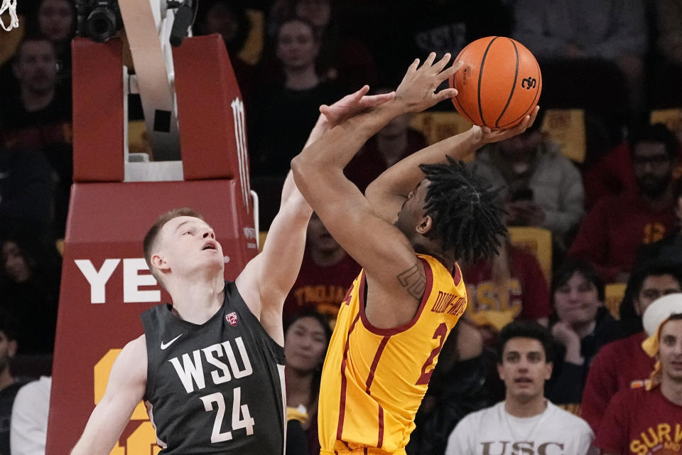 Southern California guard Reese Dixon-Waters, right, shoots as Washington State guard Justin Powell defends during the first half of an NCAA college basketball game Thursday, Feb. 2, 2023, in Los Angeles. (AP Photo/Mark J. Terrill)