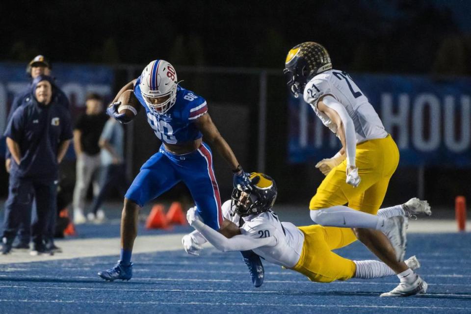Folsom Bulldogs wide receiver Brian Ray III (80) runs the ball nine yards before being pushed out-of-bounds by the Oak Ridge Trojans’ Kaleb Edwards (21) in the first half of the game on Friday, Sept. 29, 2023, at Folsom High School in Folsom