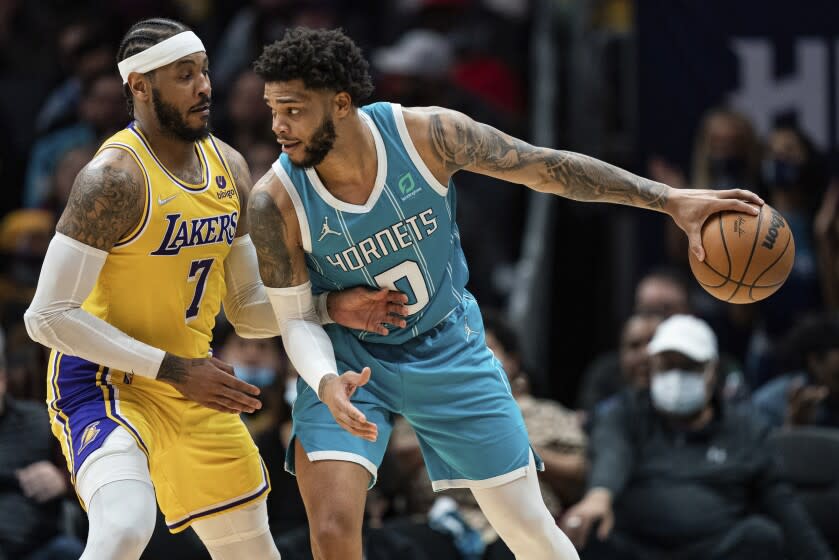 Los Angeles Lakers forward Carmelo Anthony (7) guards against Charlotte Hornets forward Miles Bridges (0) during the second half of an NBA basketball game in Charlotte, N.C., Friday, Jan. 28, 2022. (AP Photo/Jacob Kupferman)