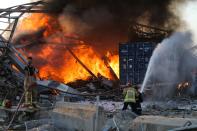 Firefighters douse a blaze at the scene of an explosion at the port of Lebanon's capital Beirut on August 4, 2020. - Two huge explosion rocked the Lebanese capital Beirut, wounding dozens of people, shaking buildings and sending huge plumes of smoke billowing into the sky. Lebanese media carried images of people trapped under rubble, some bloodied, after the massive explosions, the cause of which was not immediately known. (Photo by STR / AFP) (Photo by STR/AFP via Getty Images)