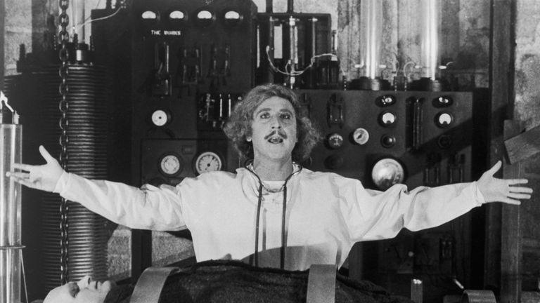 dr frederick frankenstein stands over a body in a scene from young frankenstein a good housekeeping pick for best halloween movies