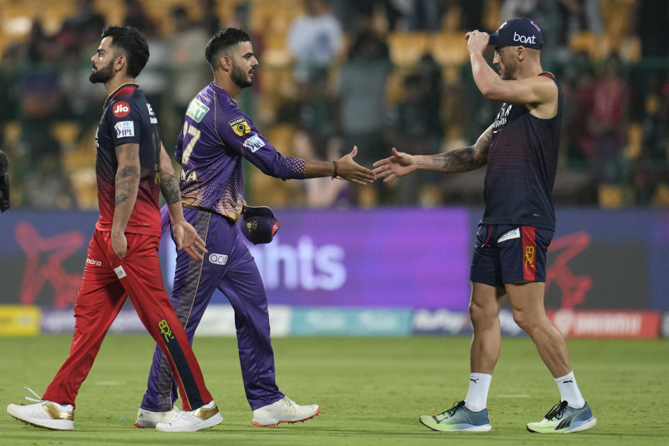 Kolkata Knight Riders' captain Nitish Rana, center, shakes hands with Royal Challengers Bangalore's Faf du Plessis, right, as Virat Kohli walks past after Kolkata Knight Riders won the Indian Premier League cricket match against Royal Challengers Bangalore in Bengaluru, India, Wednesday, April 26, 2023. (AP Photo/Aijaz Rahi)