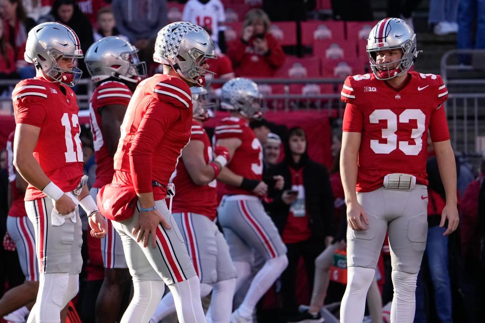 Nov 18, 2023; Columbus, Ohio, USA; Ohio State Buckeyes quarterback Devin Brown (33) and quarterback Lincoln Kienholz (12) watch as quarterback Kyle McCord (6) warms up prior to the NCAA football game against the Minnesota Golden Gophers at Ohio Stadium.