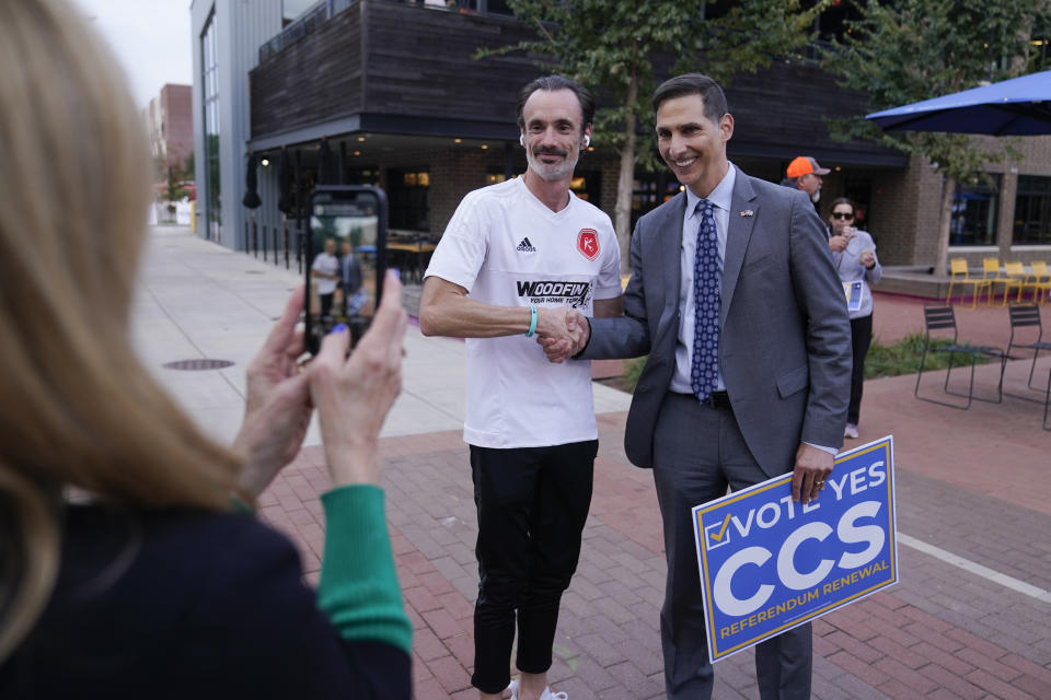 Democrat mayoral candidate Miles Nelson, right, poses with Adam Scoggin along the Monon Trail in Carmel, Ind., Wednesday, Oct. 18, 2023. Nelson faces Republican Sue Finkam in the November election. (AP Photo/Michael Conroy)