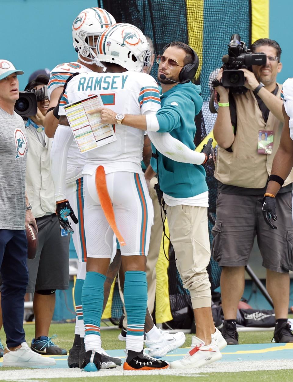 Miami Dolphins coach Mike McDaniel, center right, congratulates Jalen Ramsey, center left, on his interception in the second quarter of an NFL football game against the New England Patriots in Miami Gardens, Fla., Sunday, Oct. 29, 2023. (Al Diaz/Miami Herald via AP)