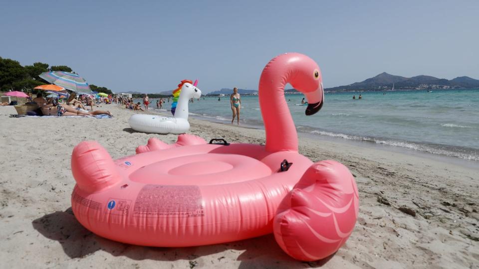 Ein aufblasbarer rosa Flamingo liegt am Strand von Playa de Muro im Norden von Mallorca.