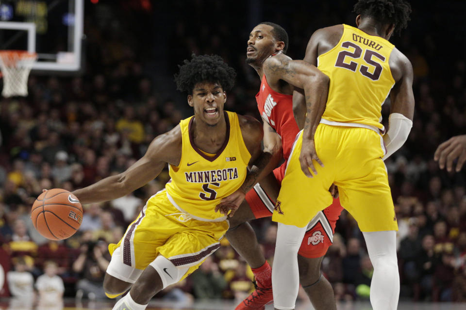 Minnesota guard Marcus Carr (5) drives around a pick by Minnesota center Daniel Oturu (25) as Ohio State guard Luther Muhammad player defense in the first half during a NCAA basketball game Sunday, Dec. 15, 2019 in Minneapolis. (AP Photo/Andy Clayton-King)