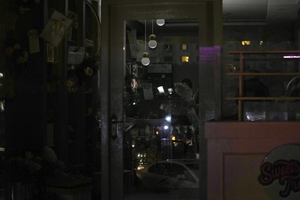 A shopkeeper use a battery light at his shop during a national-wide power breakdown, in Islamabad, Pakistan, Monday, Jan. 23, 2023. Much of Pakistan was left without power Monday as an energy-saving measure by the government backfired. The outage spread panic and raised questions about the cash-strapped government's handling of the country's economic crisis. (AP Photo/Anjum Naveed)