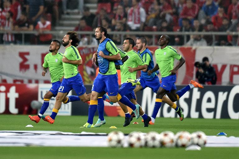 Juventus' Andrea Pirlo (2nd L) and his teammates warm up prior to an UEFA Champions League match against Olympiacos, in Athens, on October 22, 2014
