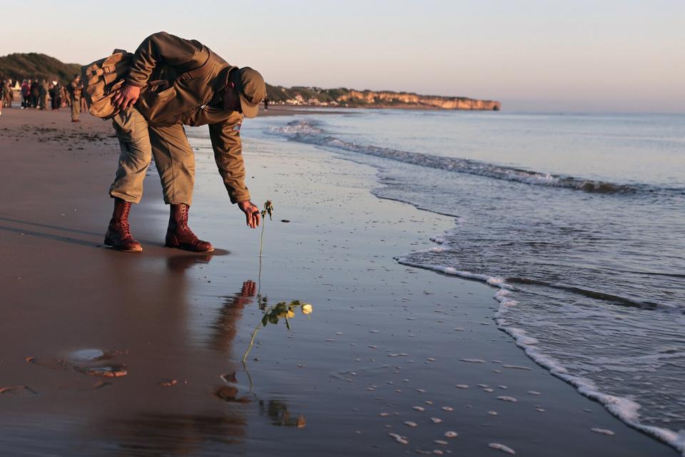World War II reenactor put roses and flowers at dawn on Omaha Beach, in Saint-Laurent-sur-Mer, Normandy, France, the day of 78th anniversary of the assault that helped bring an end to World War II