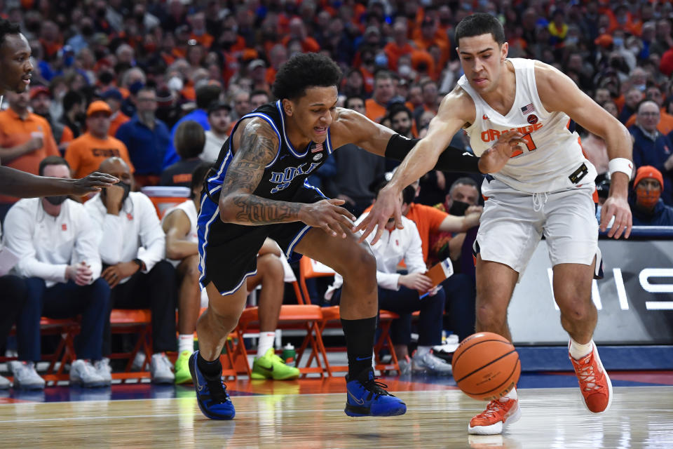 Duke forward Paolo Banchero, left, and Syracuse forward Cole Swider chase the ball during the first half of an NCAA college basketball game in Syracuse, N.Y., Saturday, Feb. 26, 2022. (AP Photo/Adrian Kraus)