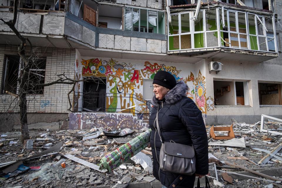 A resident passes a destroyed residential building following overnight shelling in Kherson yesterday (EPA)