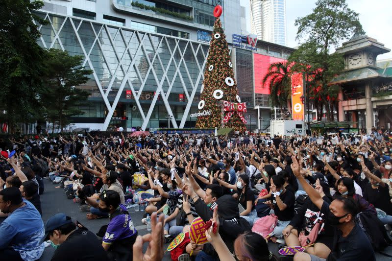 Pro-democracy demonstrators show the three-finger salute during a rally in Bangkok