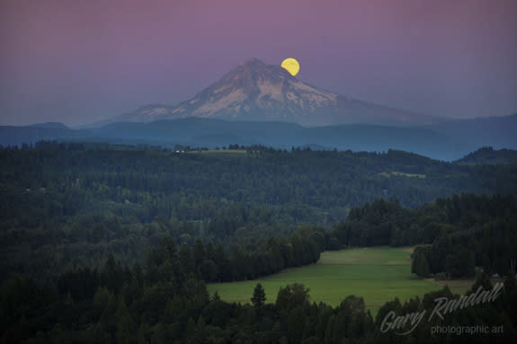 The blue moon shines behind Mount Hood, Oregon, in this photo by Gary Randall.