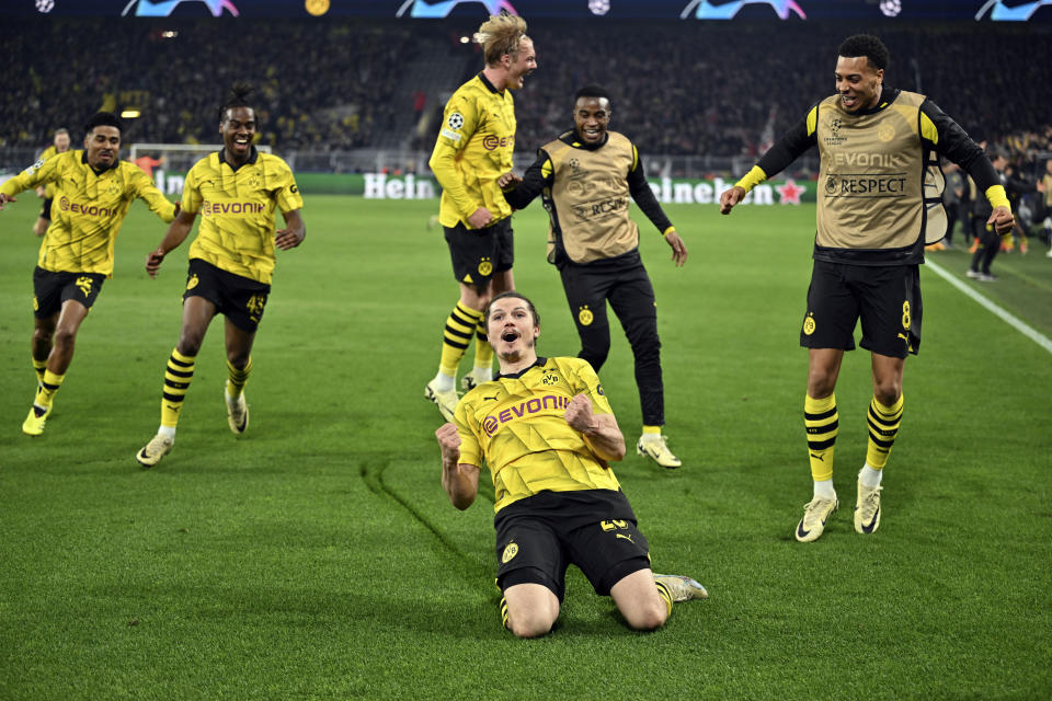 Marcel Sabitzer del Borussia Dortmund celebra con sus compañeros tras anotar el cuarto gol en el duelo de vuelta de los cuartos de final de la Liga de Campeones ante el Atlético de Madrid en el Signal-Iduna Park en Dortmund, Alemania el martes 16 de abril del 2024. (Bernd Thissen/dpa via AP)