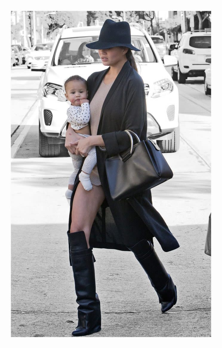 Chrissy Teigen, with daughter Luna, wore super-short shorts that made it look as if she’d stepped out without any pants on. (Photo: Splash News)