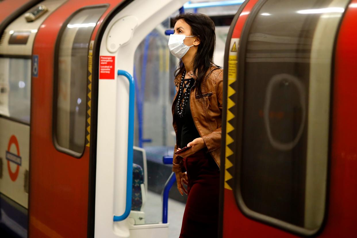 A commuter wears a facemask as she disembarks  at a tube station in London on June  5, 2020, as lockdown measures are eased during the novel coronavirus COVID-19 pandemic. - Face coverings will soon be compulsory for people wanting to travel on public transport in England to limit the spread of coronavirus. (Photo by Tolga Akmen / AFP) (Photo by TOLGA AKMEN/AFP via Getty Images)