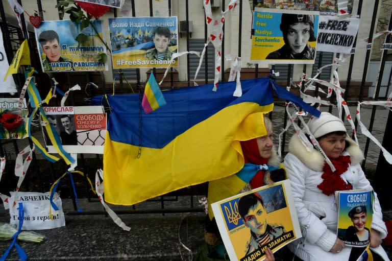 People hold portraits of Ukrainian military pilot Nadiya Savchenko during a demonstration in front of the Russian embassy in Kiev on March 22, 2016