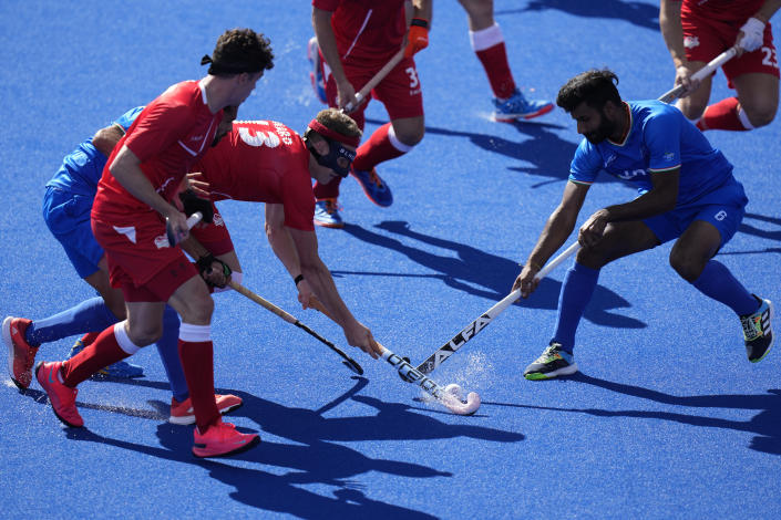 England's Samuel Ward, (in mask) vies for the ball with India's Hardik Singh, right, during pool B hockey match between India and England at the Commonwealth Games in Birmingham, England, Sunday, July 31, 2022. (AP Photo/Alastair Grant)