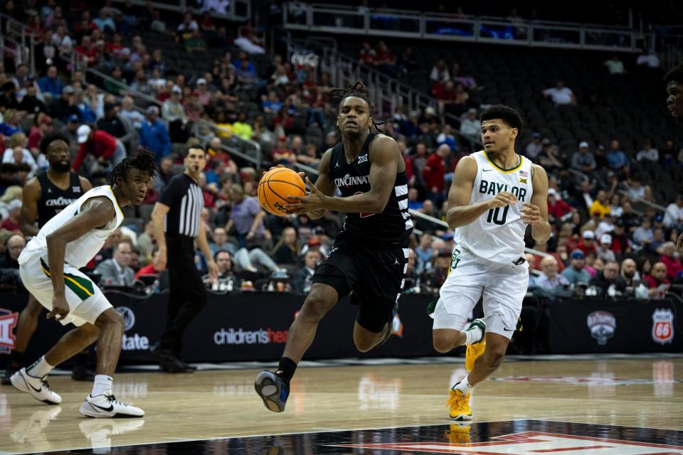 Cincinnati Bearcats guard Jizzle James (2) drives on Baylor Bears guard RayJ Dennis (10) in UC's Big 12 quarterfinal loss Thursday. UC hopes to land a bid to continue its season Sunday.