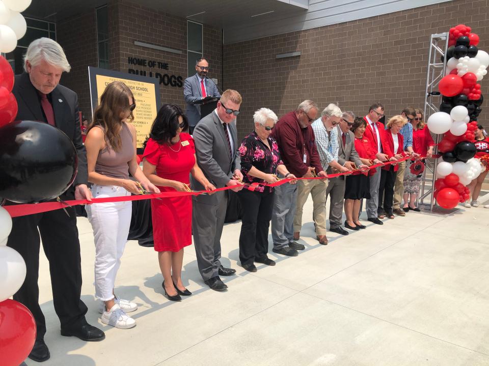 Stakeholders cut the ribbon outside the new Centennial High School on May 22, 2023.