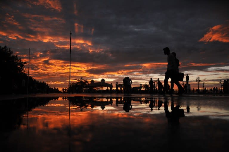 <p>Pedestrians walk during sunset after a heavy rainfall in the northern hill town of Shimla on August 18, 2016. </p>