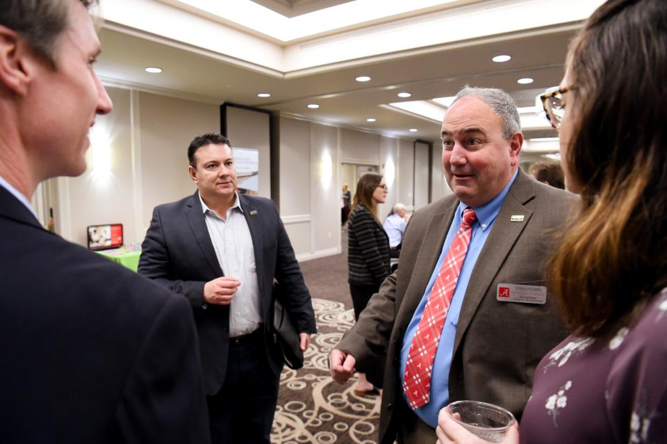 Frank Mortl III, center left, executive director of ACGIH, and Donald Elswick, executive director of the University of Alabama SafeState program in the College of Continuing Studies, talk to attendees before a session at Hotel Capstone in Tuscaloosa on Wednesday. The Alabama Healthy Homes project aims to help people in rural Alabama renovate homes to ensure the structures are not contributing to health problems.