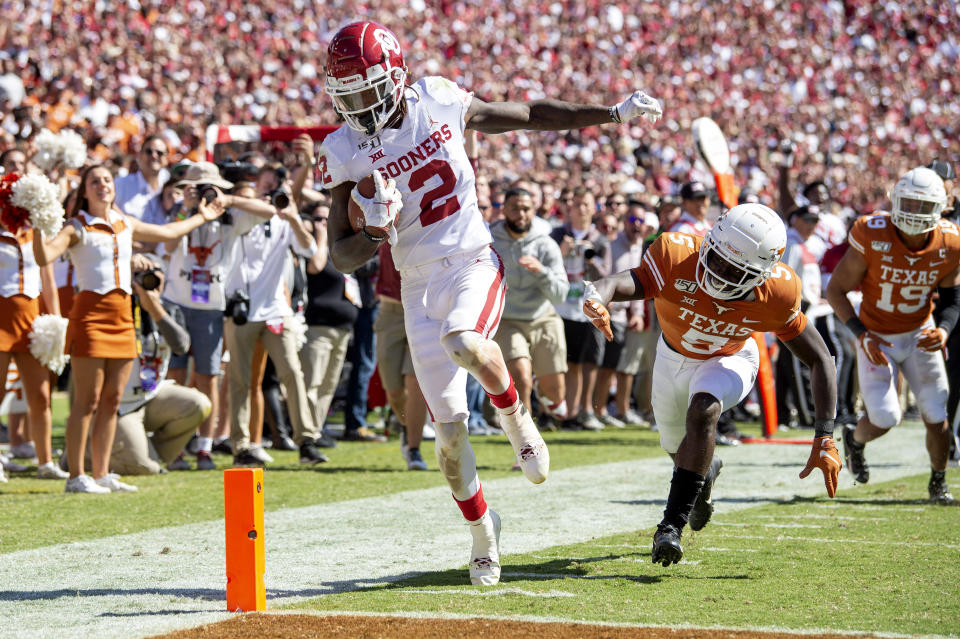 Oklahoma wide receiver CeeDee Lamb (2) scores on his third touchdown reception of the game in front of Texas defensive back D'Shawn Jamison (5) in the second half of an NCAA college football game at the Cotton Bowl, Saturday, Oct. 12, 2019, in Dallas. Lamb finished the game with 171 receiving yards as Oklahoma won 34-27. (AP Photo/Jeffrey McWhorter)
