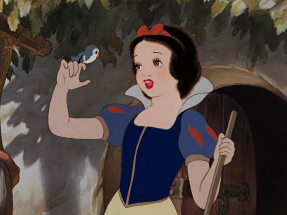 A screenshot from "Snow White and the Seven Dwarves. where shes looking at a bird on her finger.