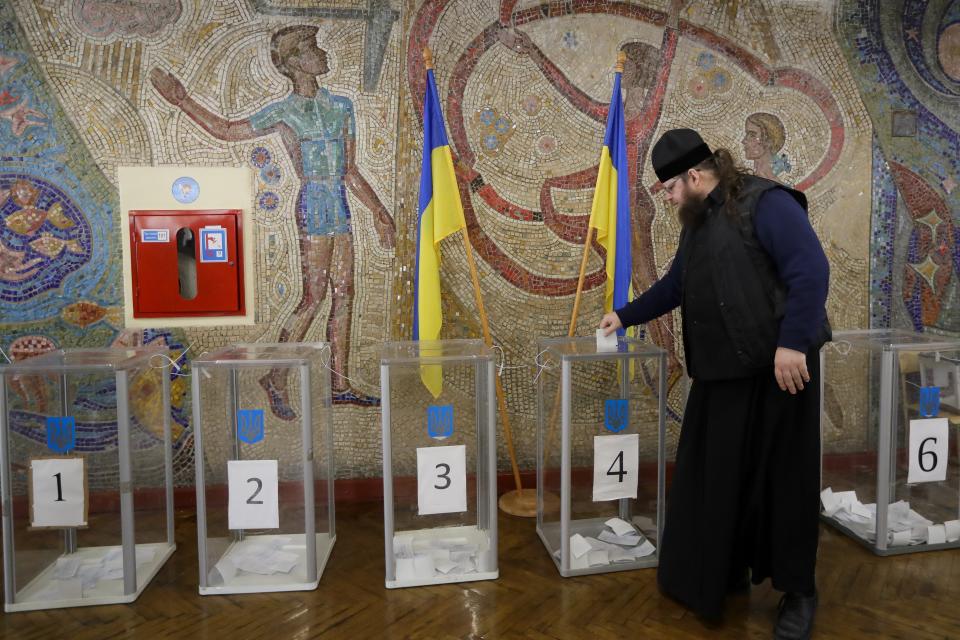 An Orthodox priest casts his ballot at a polling station, during the second round of presidential elections in Kiev, Ukraine, Sunday, April 21, 2019. Top issues in the election have been corruption, the economy and how to end the conflict with Russia-backed rebels in eastern Ukraine. (AP Photo/Sergei Grits)