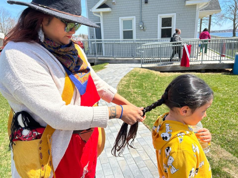 Jaimie Augustine braids her daughter Jasmine's hair before the Red Dress Walk.