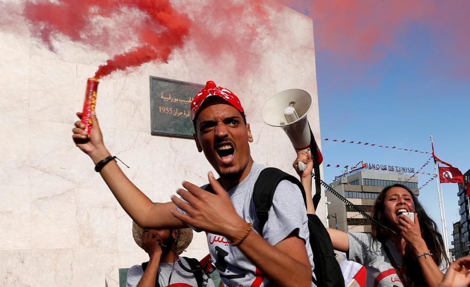 Demonstrators hold flares in Tunis