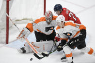 Philadelphia Flyers goaltender Alex Lyon (34) and defenseman Justin Braun (61) work for the puck against Washington Capitals left wing Conor Sheary (73) during the third period of an NHL hockey game Saturday, May 8, 2021, in Washington. The Capitals won 2-1 in overtime. (AP Photo/Nick Wass)