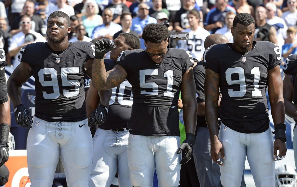<p>Oakland Raiders outside linebacker Bruce Irvin (51) raises a fist during the playing of the national anthem before an NFL football game against the Tennessee Titans Sunday, Sept. 25, 2016, in Nashville, Tenn. At left is defensive end Jihad Ward (95) and at right is linebacker Shilique Calhoun (91). (AP Photo/Mark Zaleski) </p>