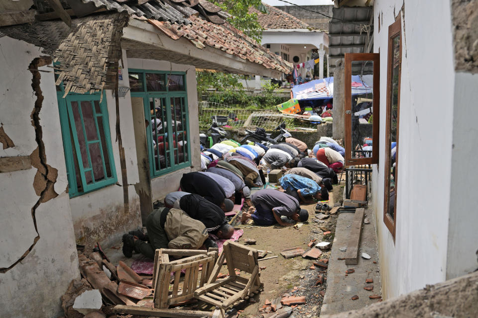 Muslim men perform a Friday prayer outside a mosque badly damaged in Monday's earthquake, in Gasol village, Cianjur, West Java, Indonesia, Friday, Nov. 25, 2022. The quake on Monday killed hundreds of people, many of them children and injured thousands. (AP Photo/Achmad Ibrahim)