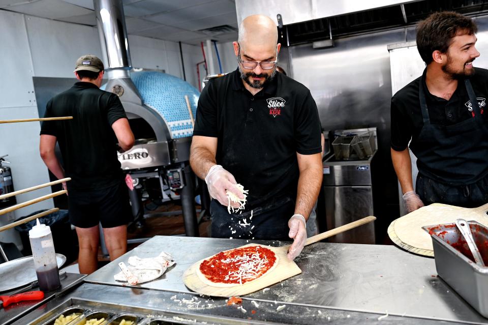 Employee Eric Kumor makes a pizza at the Slice by Saddleback south Lansing location on Thursday, Aug. 11, 2022.