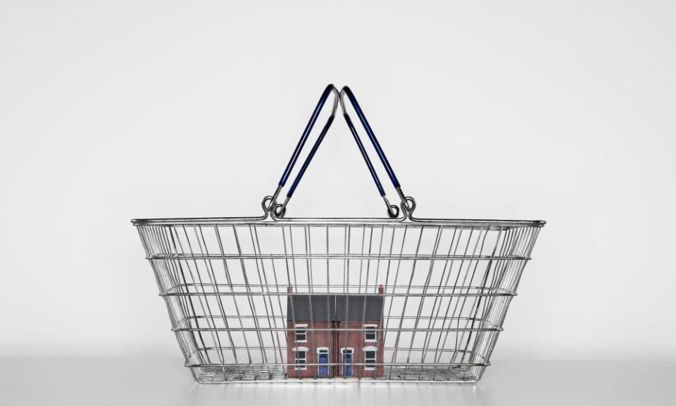 A model of a red bricked house in a shopping basket.