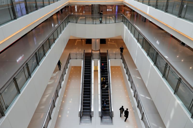 People wear protective masks as they walk inside a shopping mall, following the outbreak of the new coronavirus, in Hong Kong