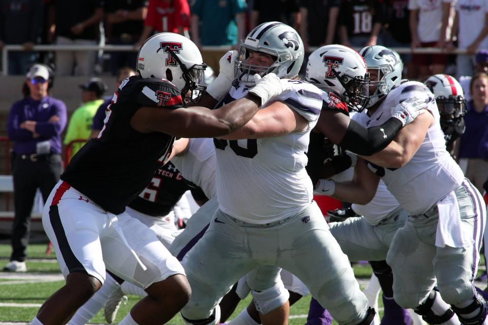 Kansas State offensive lineman Cooper Beebe (50) blocks Texas Tech's Tyrie Wilson (19) during a 2021 game in Lubbock, Texas.